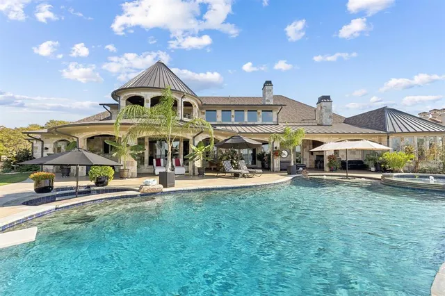 a view of a building with a garden and parking space