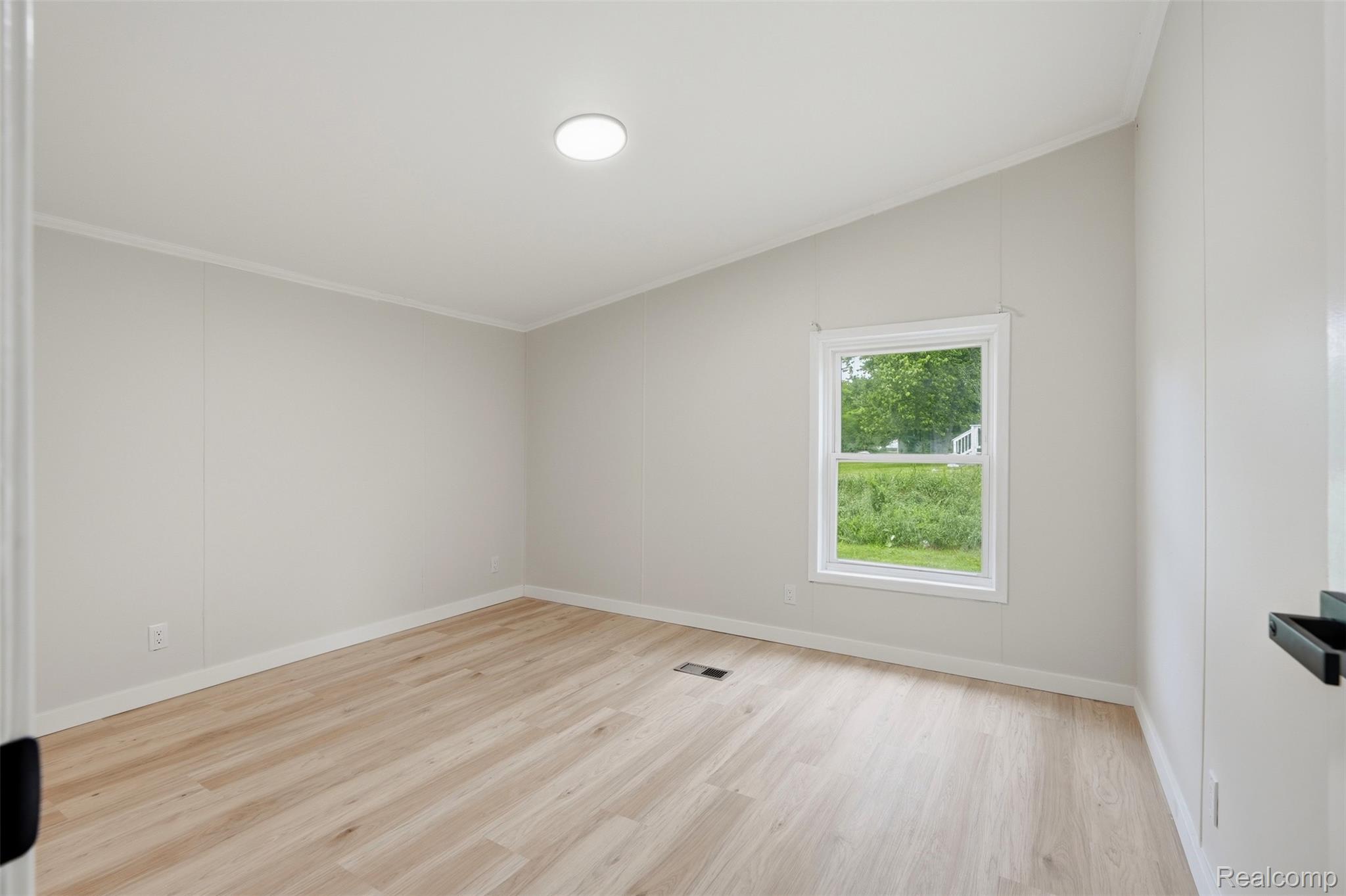 4420 Dublin Road Burton, MI 48529 - Photo 26 of 56 Room featuring light wood-finish flooring, white baseboards, and a single window with white trim