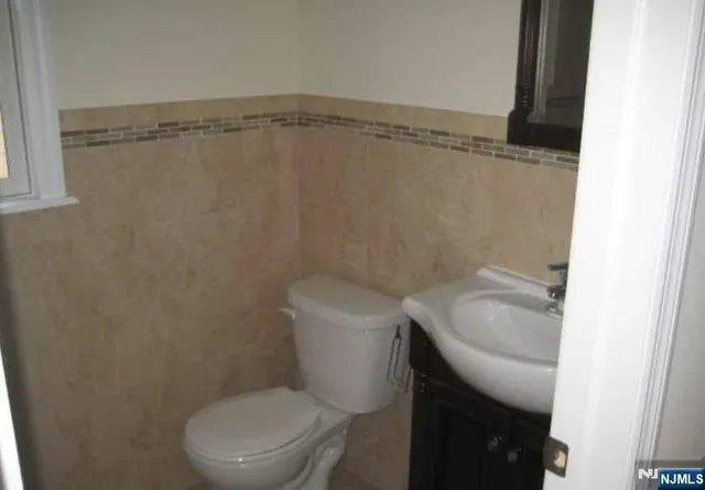 a white toilet sitting next to a shower
