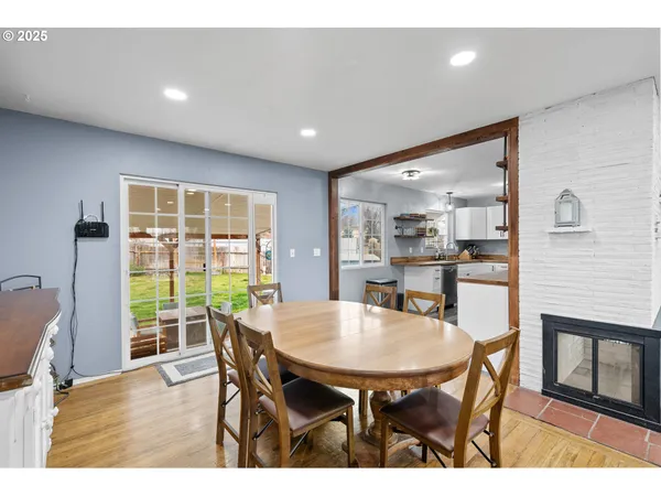 a kitchen with stainless steel appliances kitchen island granite countertop a dining table chairs and refrigerator