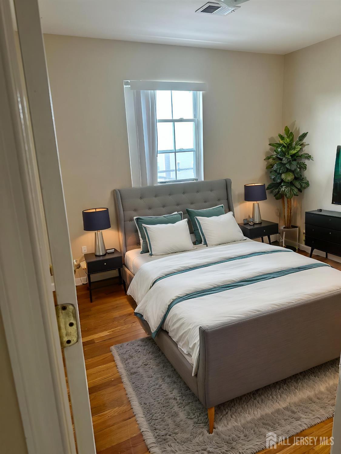 663 South Park Street Elizabeth, NJ 07206 - Photo 4 of 11 a bedroom with a large bed and a potted plant