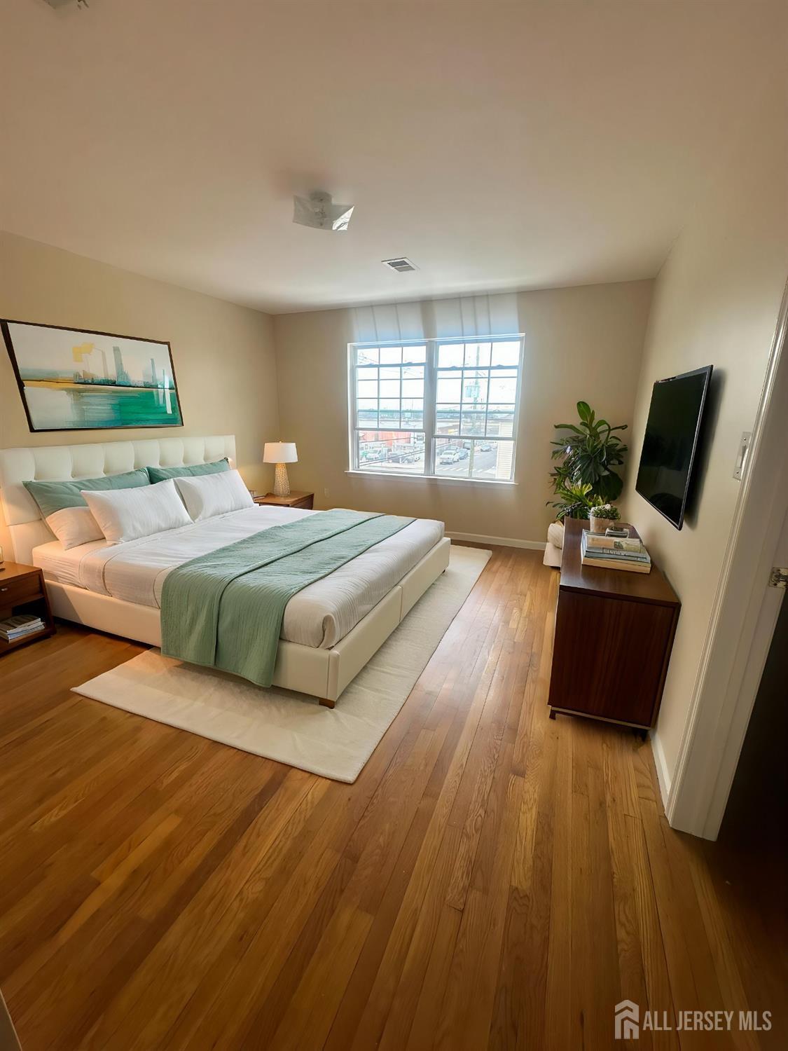663 South Park Street Elizabeth, NJ 07206 - Photo 5 of 11 a bedroom with a bed and wooden floor