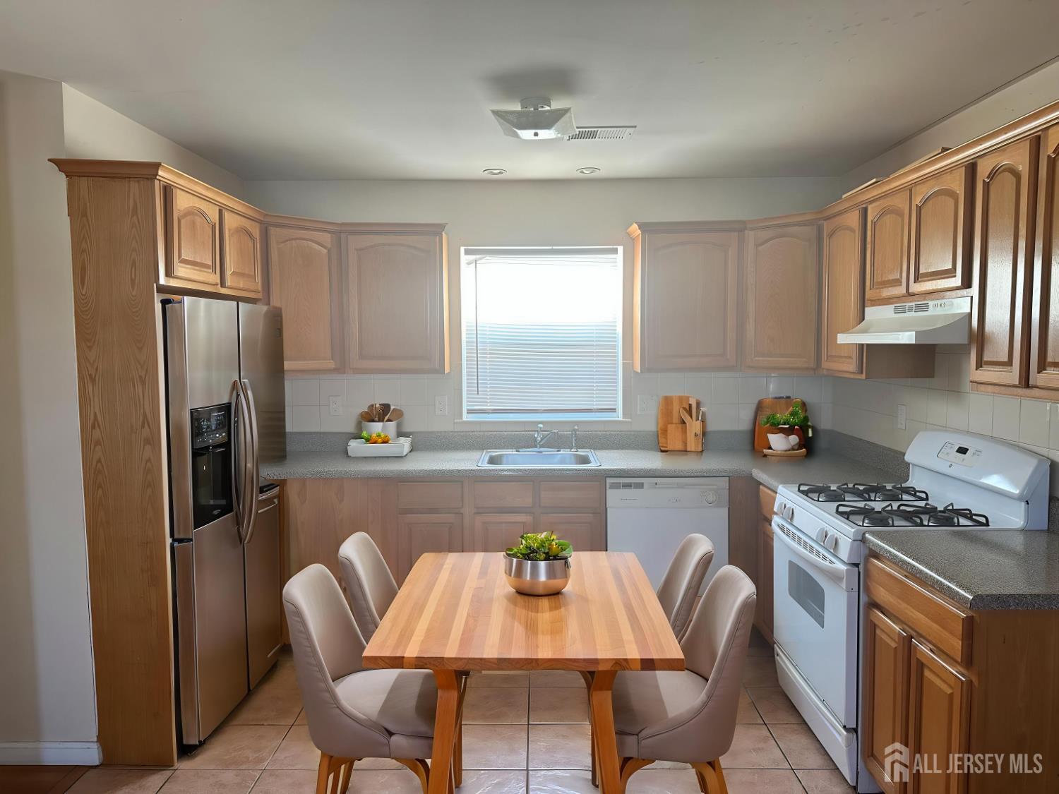 663 South Park Street Elizabeth, NJ 07206 - Photo 6 of 11 a kitchen with stainless steel appliances granite countertop a dining table chairs refrigerator and cabinets