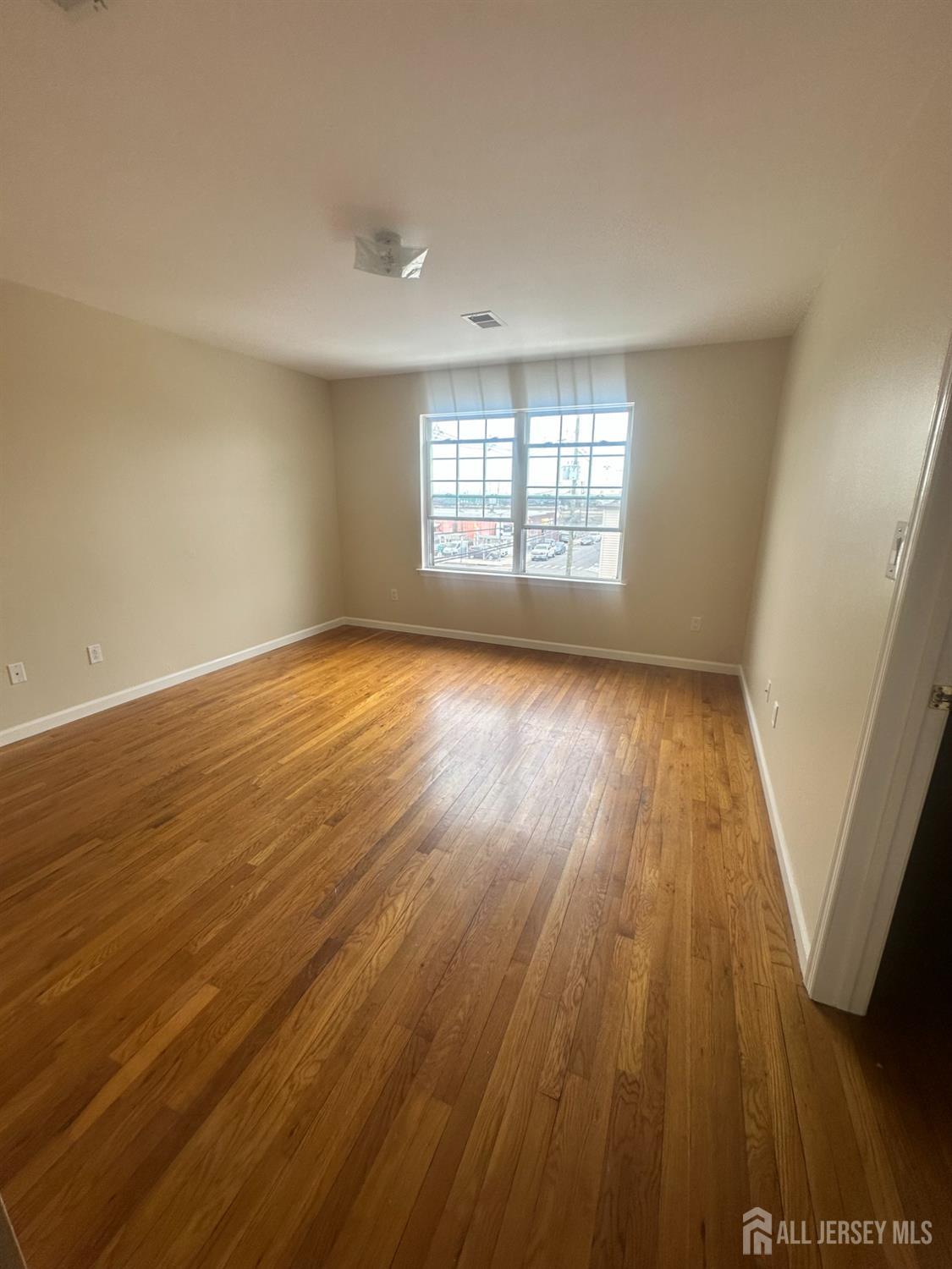 663 South Park Street Elizabeth, NJ 07206 - Photo 9 of 11 an empty room with wooden floor and windows