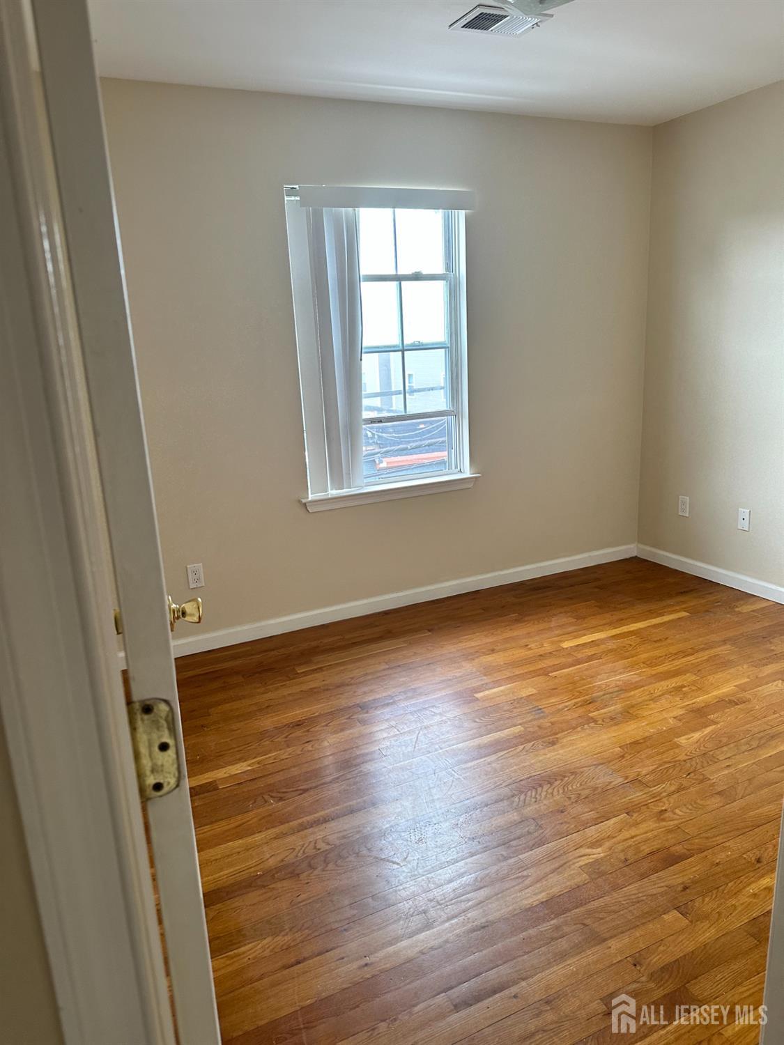 663 South Park Street Elizabeth, NJ 07206 - Photo 10 of 11 a view of an empty room with wooden floor and a window