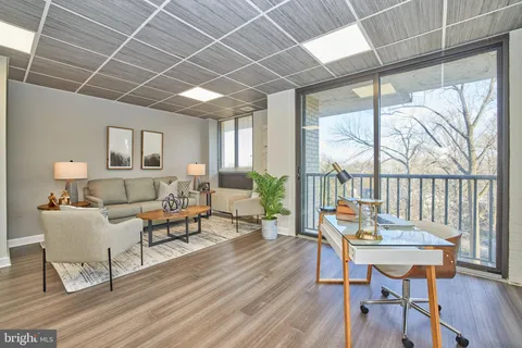 a living room with furniture a table and a large window