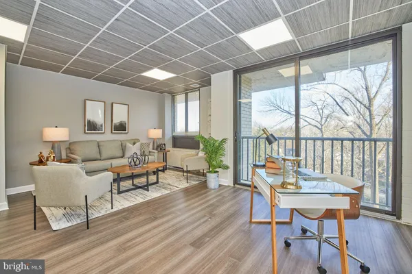 a living room with furniture a table and a large window