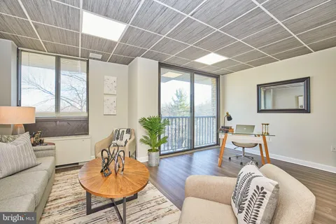 a living room with furniture or wooden floor and a large window