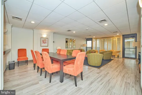 a living room with couches and kitchen view with wooden floor