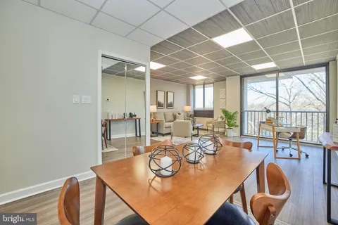 a view of a dining room with furniture large windows and wooden floor