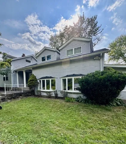 a front view of a house with a yard and potted plants