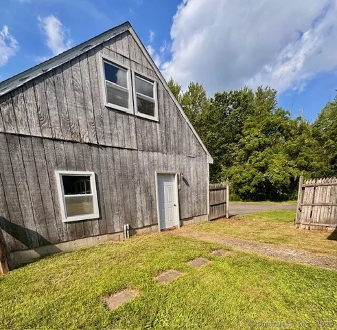 a view of backyard of house with large tree