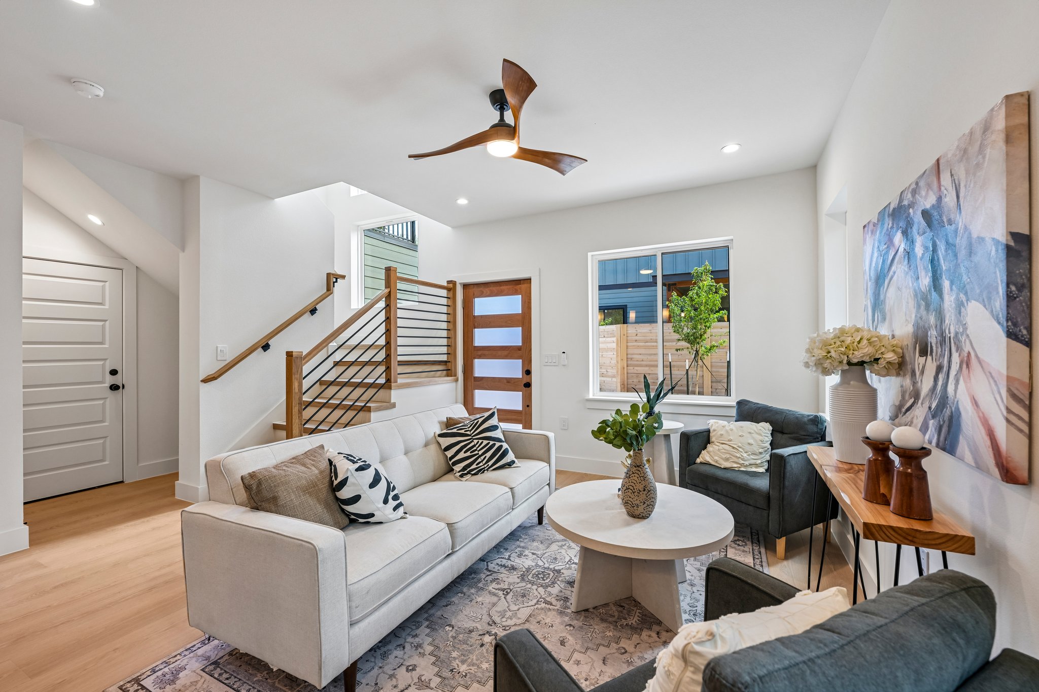 513 West Odell Street, Unit B Austin, TX 78752 - Photo 5 of 38 A contemporary living area showcasing a sleek staircase and abundant natural light.