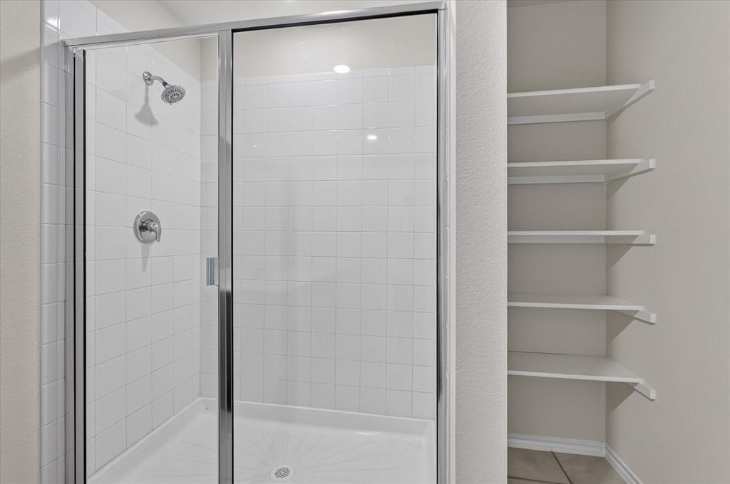 2428 Rosharon Drive Forney, TX 75126 - Photo 26 of 40 Modern primary bathroom featuring a frameless glass shower enclosure with chrome fixtures, white subway tile surround, and integrated shower lighting