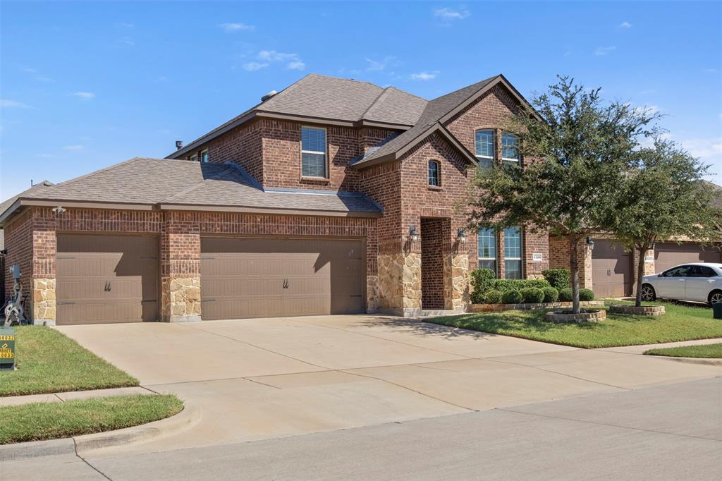 4125 Fern Loop Forney, TX 75126 - Photo 3 of 40 Brick exterior with stone accents, a multi-car garage, and established landscaping