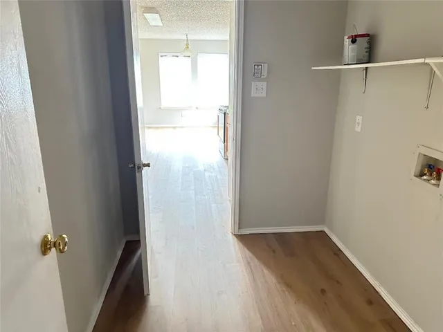 a view of a room with wooden floor and mirror