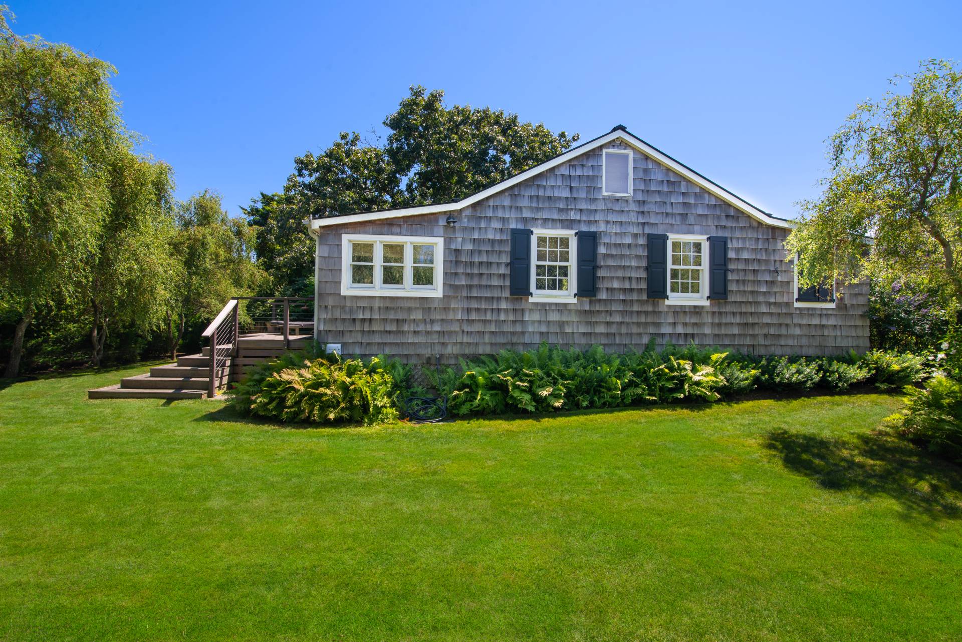 12 Jackson Road Montauk, NY 11954 - Photo 23 of 38 a front view of a house with a yard and pathway