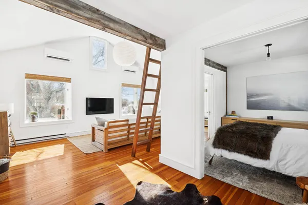 a bedroom with a bed and wooden floor