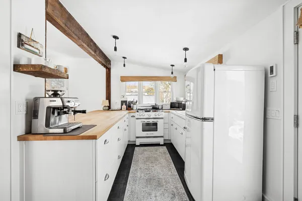 a kitchen with white cabinets and white appliances