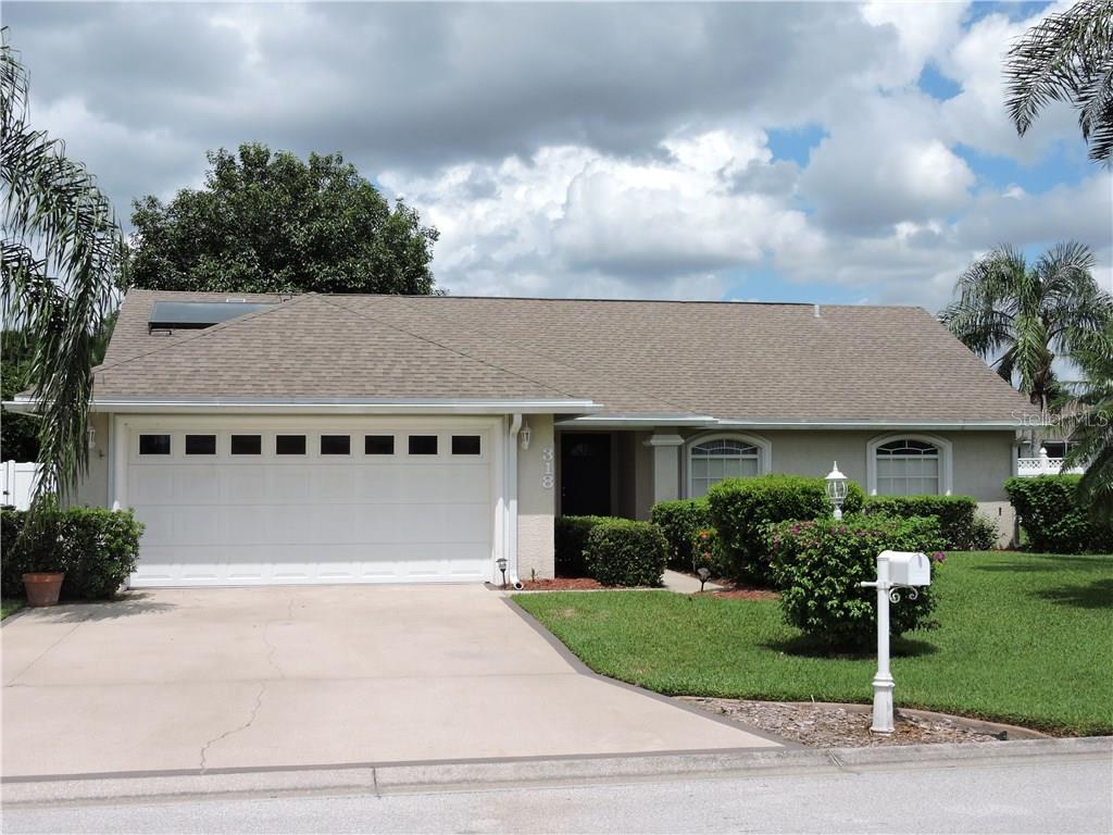a front view of house with yard and green space