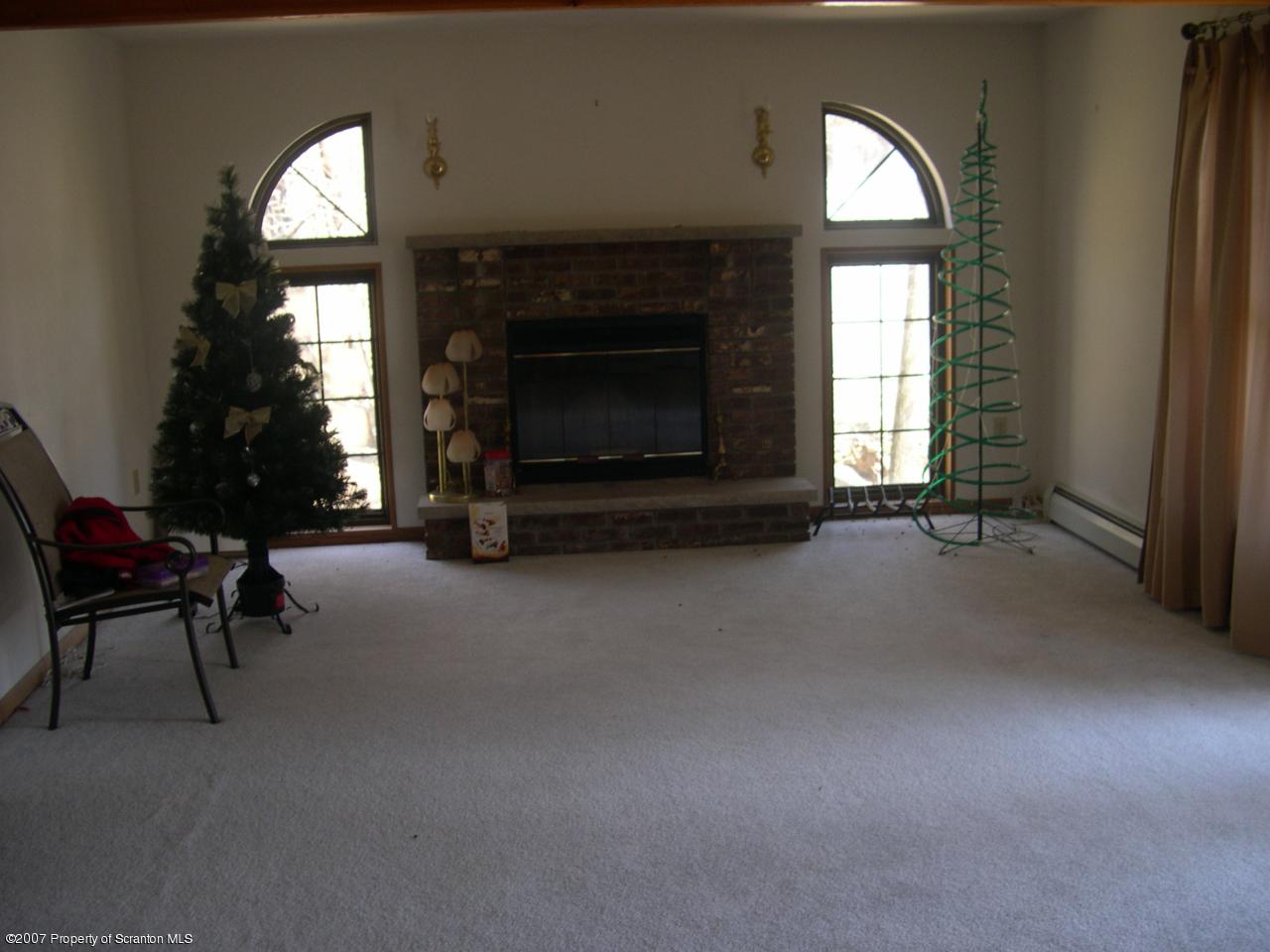 2400 Crest View Road Lake Ariel, PA 18436 - Photo 2 of 9 a living room with furniture a mirror and a fireplace