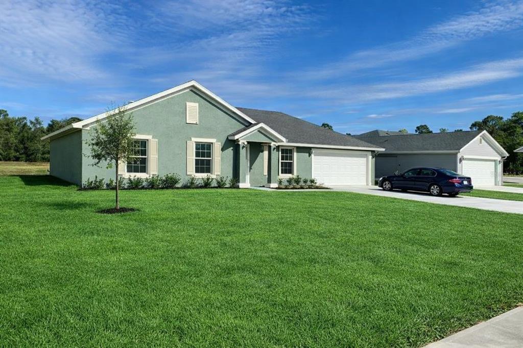 3331 Southwest 153rd Pl Road Ocala, FL 34473 - Photo 1 of 35 a front view of a house with a garden and trees