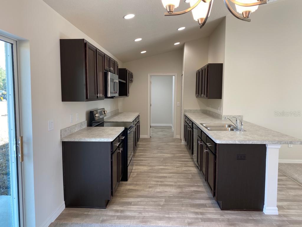 3331 Southwest 153rd Pl Road Ocala, FL 34473 - Photo 7 of 35 a kitchen with stainless steel appliances granite countertop a sink stove and refrigerator