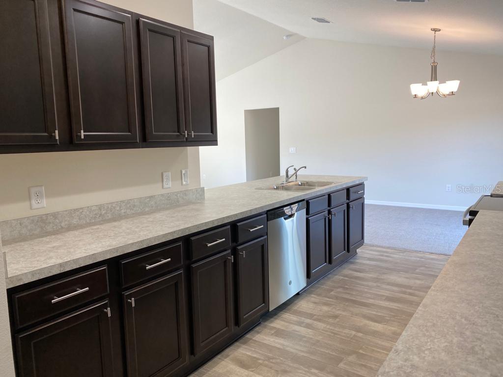 3331 Southwest 153rd Pl Road Ocala, FL 34473 - Photo 9 of 35 a kitchen with stainless steel appliances granite countertop a sink dishwasher a stove and a microwave oven