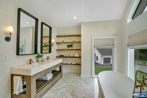 a spacious bathroom with a double vanity sink a mirror and a shower