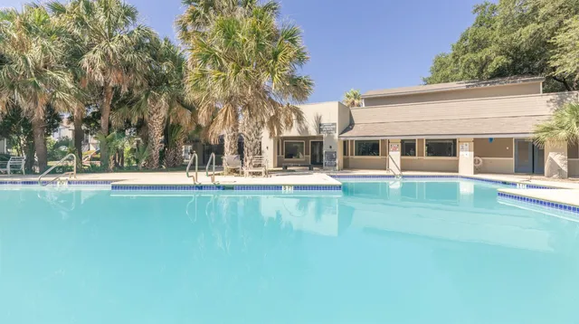 a view of swimming pool with outdoor seating and house in the background