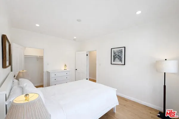 a bedroom with a bed and painting on the wall