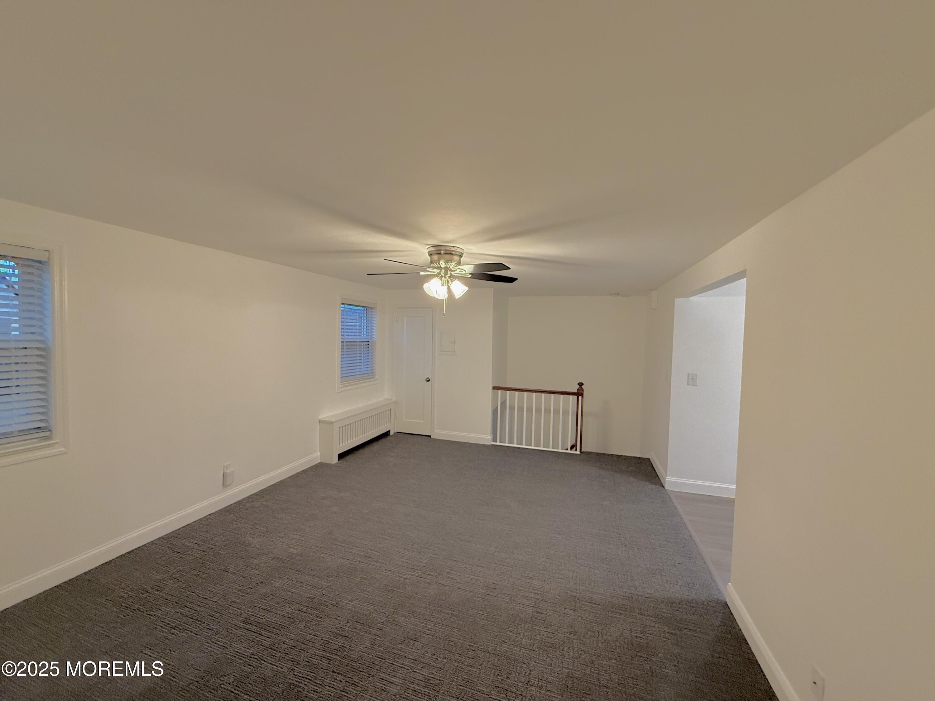 169 Manor Drive Red Bank, NJ 07701 - Photo 5 of 15 an empty room with chandelier fan and windows