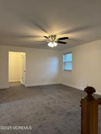 a view of a livingroom with a ceiling fan and window