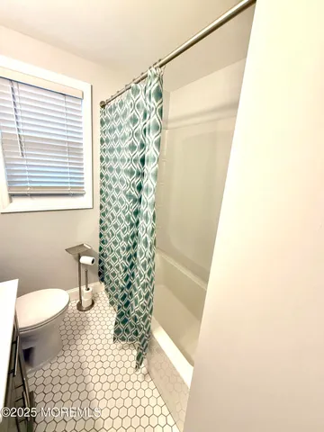 a bathroom with a shower curtain and a toilet