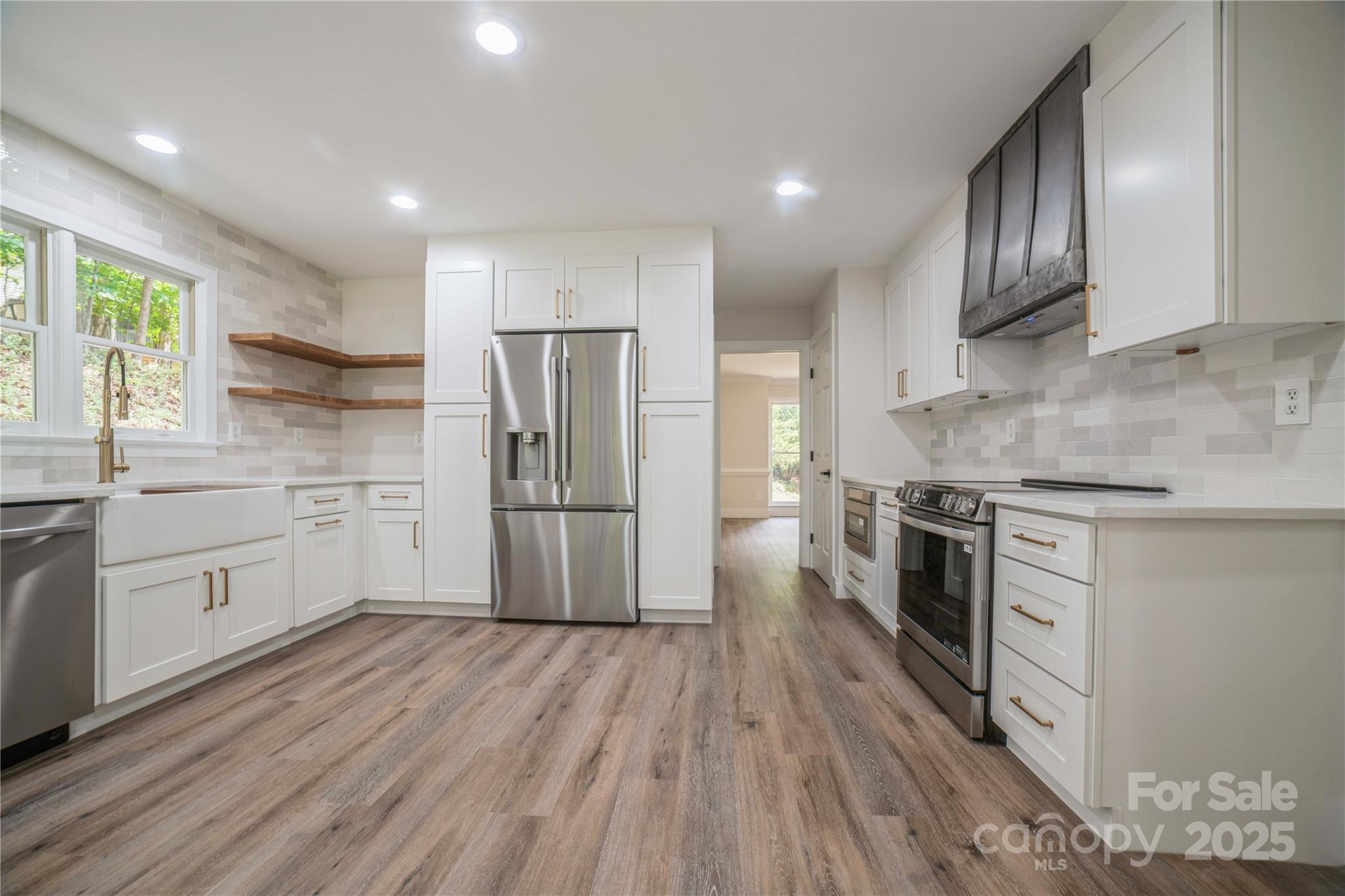 26056 Neptunes Landing Fort Mill, SC 29708 - Photo 11 of 47 a kitchen with a refrigerator a sink dishwasher a stove and white cabinets with wooden floor