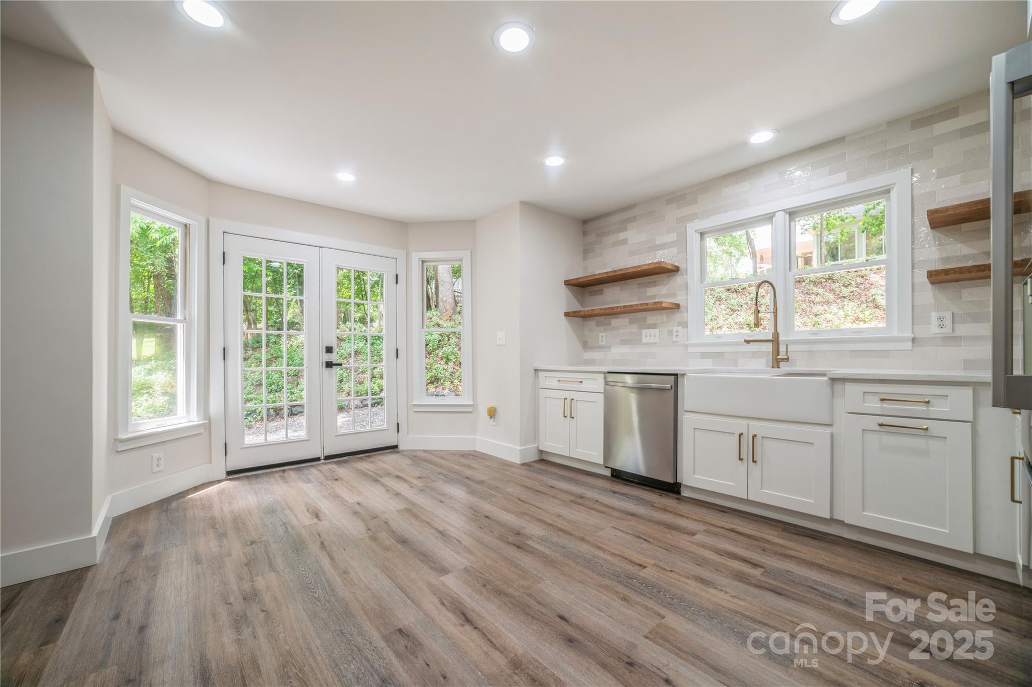 26056 Neptunes Landing Fort Mill, SC 29708 - Photo 12 of 47 a open kitchen with white cabinets and wooden floors