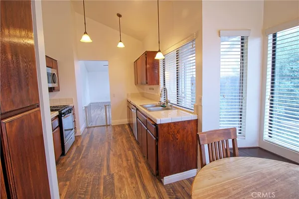 a kitchen view with wooden floor and windows
