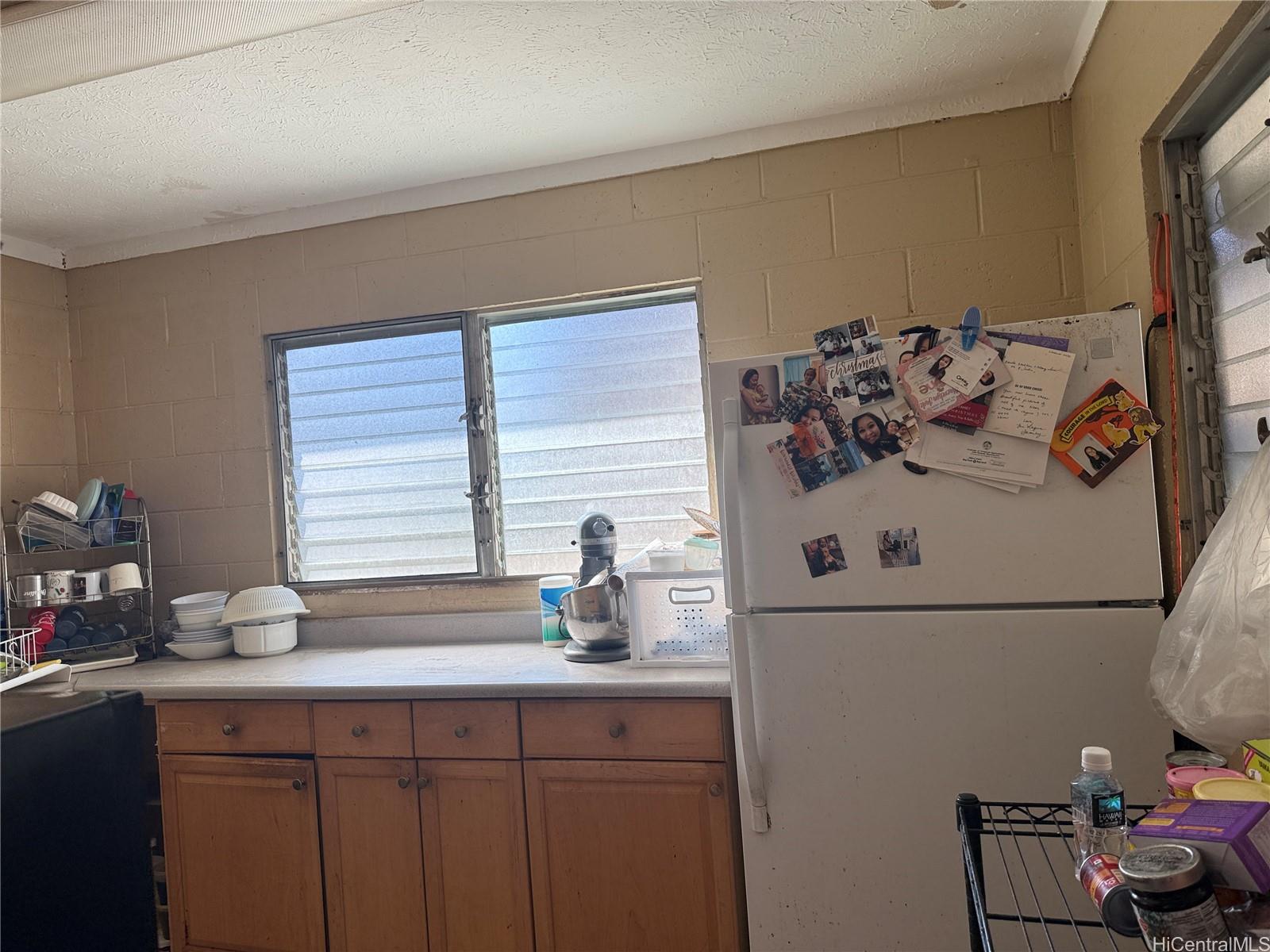 3647 Likini Street Honolulu, HI 96818 - Photo 4 of 8 a kitchen with stainless steel appliances a sink and a refrigerator