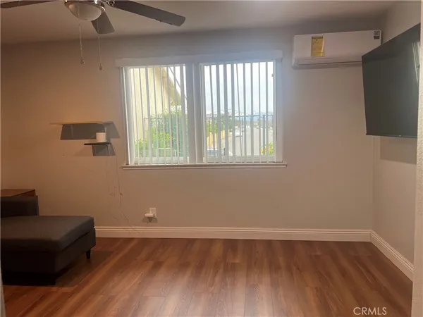 a view of a livingroom with wooden floor and a window