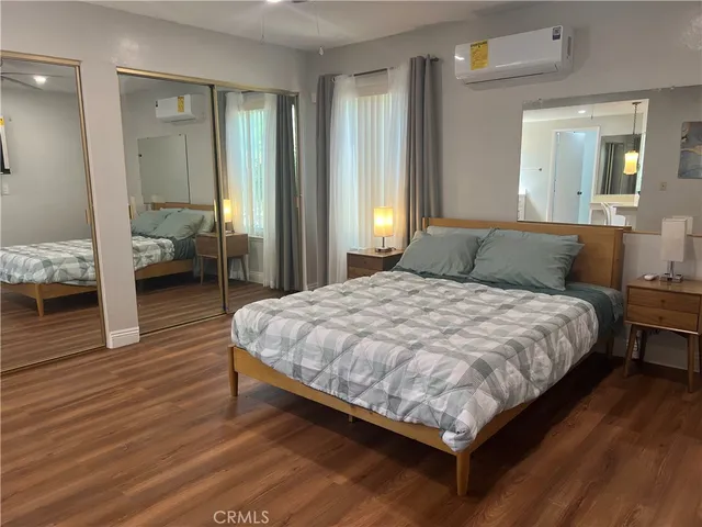 a bedroom with a bed and wooden floor