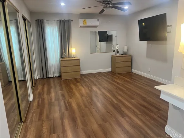 a view of a livingroom with wooden floor and a flat screen tv