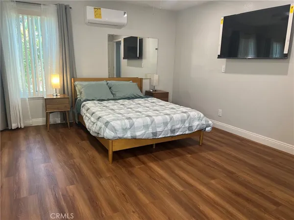 a bedroom with a bed and a flat screen tv
