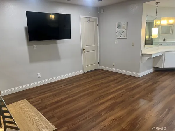 a view of a livingroom with wooden floor and a flat screen tv