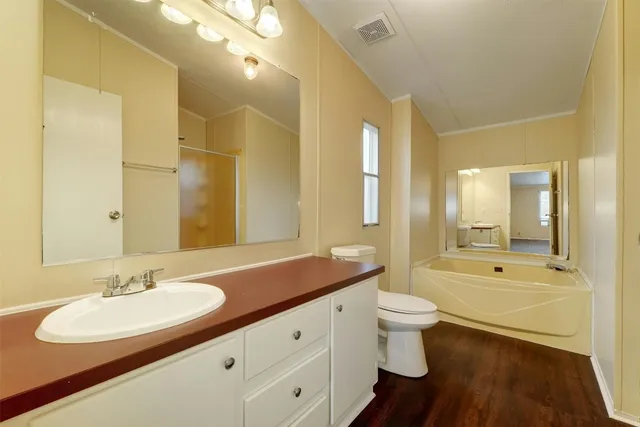 a bathroom with a sink double vanity granite and a tub