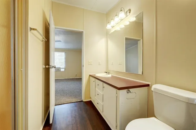 a bathroom with a sink and mirror with toilet