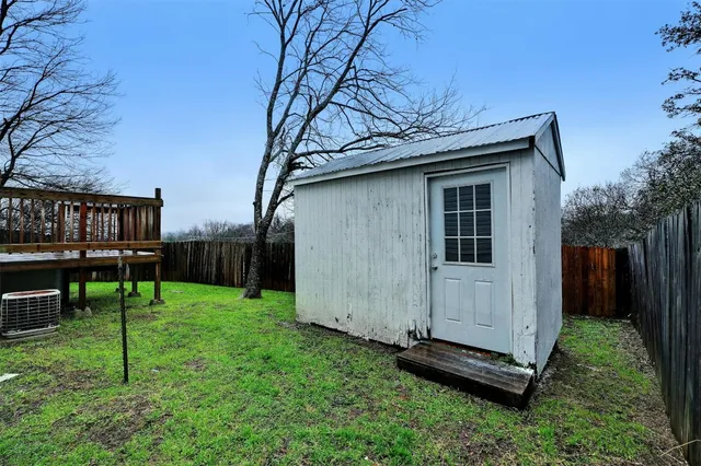 a backyard of a house with plants and wooden fence
