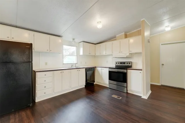 a kitchen with granite countertop white cabinets and white appliances