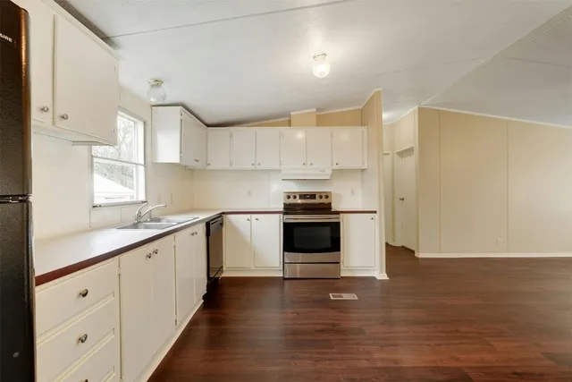 a kitchen with granite countertop white cabinets and white appliances