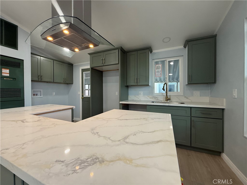 716 North Grand, Unit D3 Covina, CA 91724 - Photo 12 of 35 a large white kitchen with kitchen island a sink stainless steel appliances and cabinets