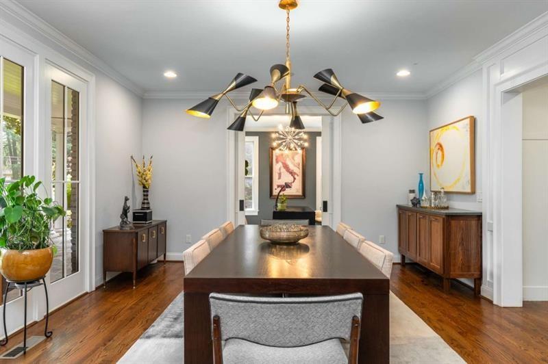 1678 Nottingham Way Northeast Atlanta, GA 30309 - Photo 14 of 57 a dining room with wooden floor a chandelier a wooden table and chairs